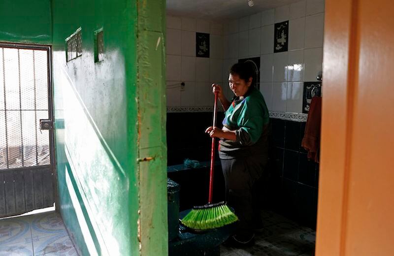 Berta Lopez cleans her home on her day off. For the last couple of years, every spare peso has gone to pay the college tuition for her youngest son. (Katie Falkenberg/Los Angeles Times/TNS)