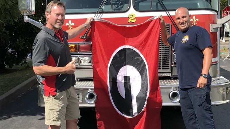 Joe Purcell (L) of Athens was more than happy to donate his “G Flag” to Nashville firefighter Justin Champion to fly on his Rescue 2 firetruck. (Chip Towers/ctowers@ajc.com)