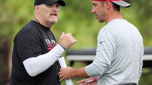 072816 FLOWERY BRANCH: Falcons head coach Dan Quinn confers with offensive coordinator Kyle Shanahan during the first day of training camp on Thursday, July 28, 2016, in Flowery Branch.   Curtis Compton /ccompton@ajc.com