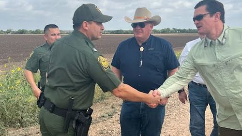U.S. Rep. Austin Scott, R-Tifton, shakes hands with a U.S. Customs and Border Patrol agent while Agriculture Committee Chairman  Glenn Thompson looks on during a visit to the Texas border with Mexico. Photo courtesy of Rep. Scott, U.S. House of Representatives.