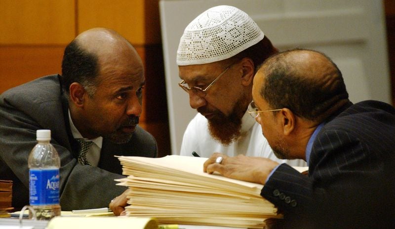 Defense lawyer Tony Axam (on left), defendant Jamil Abdullah Al-Amin, and defense lawyer Michael Warner confer during the first day of Al-Amin's trial in Fulton Superior Court .