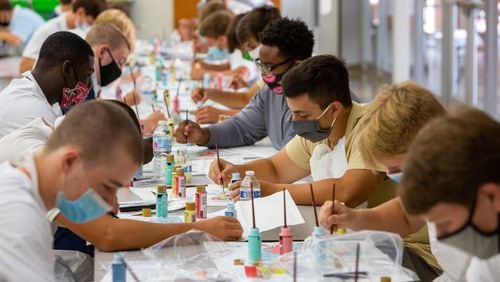St. Pius X Catholic School football players paint “heart boards” to show their support and appreciation to healthcare workers. PHIL SKINNER FOR THE ATLANTA JOURNAL-CONSTITUTION.