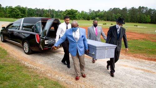 One of three coffins is removed from a hearse and taken to an area where a short service is held at Lakeside Memorial Gardens in Palmetto on Monday. (Steve Schaefer for The Atlanta Journal-Constitution)
