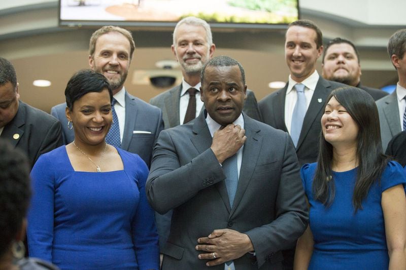 Kasim Reed adjusts his tie before a group photo including Mayor-elect Keisha Lance-Bottoms (left) during Reed’s final workday as mayor of Atlanta at City Hall on December 29, 2017. ALYSSA POINTER/ALYSSA.POINTER@AJC.COM