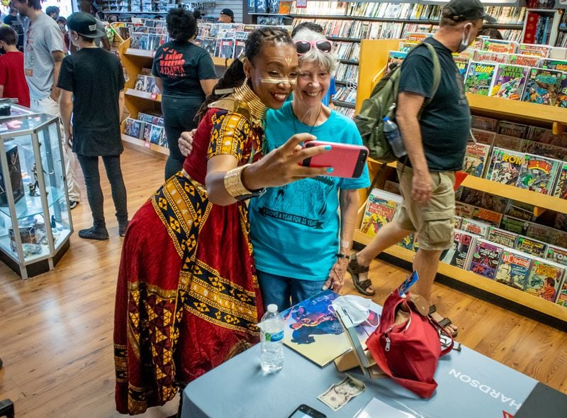 다이앤 그린이 2021년 8월 14일 토요일 로렌스빌에서 열린 무료 만화책의 날 동안 갤럭틱 퀘스트 만화책 가게에서 블랙 팬더 만화가 아푸아 리차드슨과 셀카를 위해 포즈를 취합니다. 애틀랜타 저널 구성을 위한 스티브 셰퍼