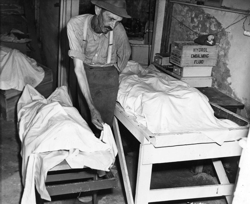 Coroner W.T. Brown places a sheet over the body of one of four Moore’s Ford victims in a funeral home at Monroe in 1946. The four were seized while riding with a white farmer, and were taken into woods and shot. (Associated Press photo)