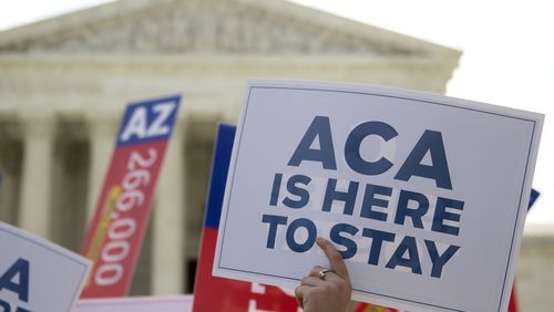 A demonstrator in support of U.S. President Barack Obama's health-care law, the Affordable Care Act (ACA), holds up a sign after the U.S. Supreme Court ruled 6-3 to save Obamacare tax subsidies outside the Supreme Court in Washington. Bloomberg/Andrew Harrer