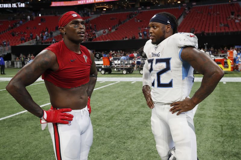Former Alabama football players Atlanta Falcons wide receiver Julio Jones, left, and Tennessee Titans running back Derrick Henry speak after an NFL football game, Sunday, Sept. 29, 2019, in Atlanta. The Tennessee Titans won 24-10. (AP Photo/John Bazemore)