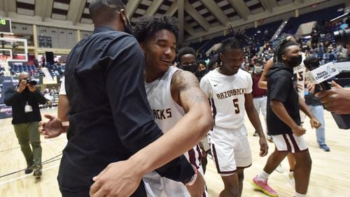 March 12, 2021 Macon - Cross Creek's Richard Visitacion (4) gets a hug from Cross Creek's head coach Lawrence M Kelly (left) after they defeated Sandy Creek during the 2021 GHSA State Basketball Class AAA Boys Championship game at the Macon Centreplex in Macon on Friday, March 12, 2021 Cross Creek won 57-49 over Sandy Creek. (Hyosub Shin / Hyosub.Shin@ajc.com)