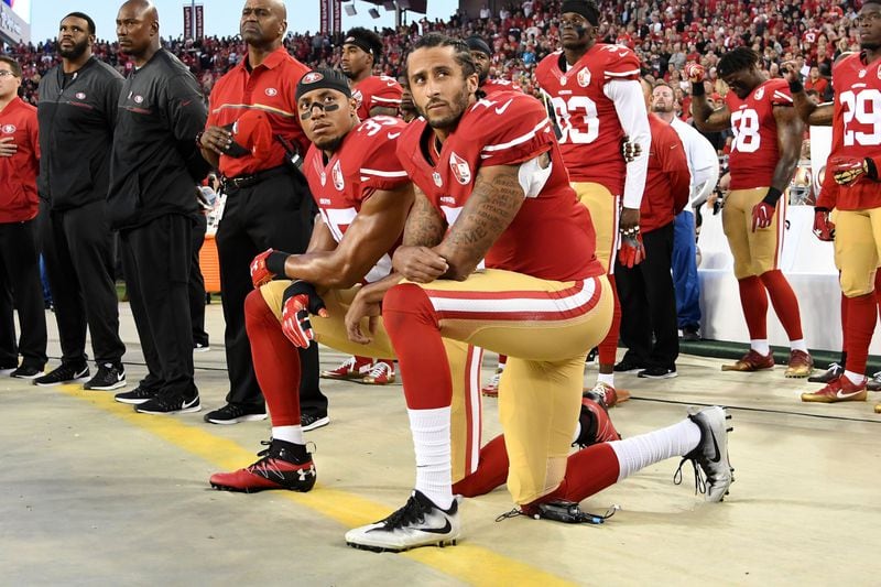 Former 49ers teammates Colin Kaepernick (7) and Eric Reid take a knee during the national anthem in 2016.