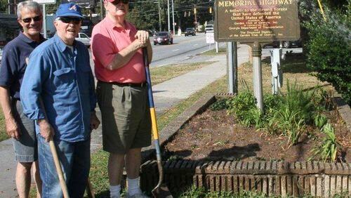 Buckhead Men’s Garden Club members Allen Ferrell, Earl Masters and Rowland Hawthorne work at the marker in front of the Atlanta fire station on Roswell Road in 2013. The Buckhead Men’s Garden Club, which recently disbanded, planted the garden as a part of its beautification efforts. CONTRIBUTED