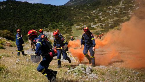 Firefighters of the 1st Wildfire Special Operation Unit, take part in a drill near Villia village some 60 kilometers (37 miles) northwest of Athens, Greece, Friday, April 19, 2024. Greece's fire season officially starts on May 1 but dozens of fires have already been put out over the past month after temperatures began hitting 30 degrees Celsius (86 degrees Fahrenheit) in late March. This year, Greece is doubling the number of firefighters in specialized units to some 1,300, adopting tactics from the United States to try and outflank fires with airborne units scrambled to build breaks in the predicted path of the flames. (AP Photo/Thanassis Stavrakis)