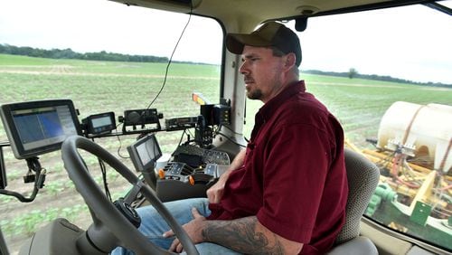 Todd Whitfield monitors the application of liquid nitrogen to a cotton field owned by Chuck and Matt Coley in Vienna on June 10, 2015. Whitfield has a host of electronics to monitor, but he doesn't have to actually steer the tractor. The auto steer tractor is able to prevent the overlapping application of chemicals.