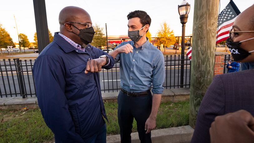 Democratic candidates for U.S. Senate Jon Ossoff and Raphael Warnock, left, elbow bump after a meet and greet with supporters at the Cobb Civic Center on Sunday, Nov.15, 2020, in Marietta, Ga. (JOHN AMIS FOR THE ATLANTA JOURNAL-CONSTITUTION)