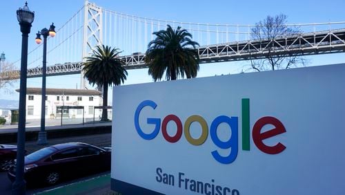 FILE - The San Francisco-Oakland Bay Bridge is seen behind a Google sign at the company's office in San Francisco, April 12, 2023. Lawyers for both the Department of Justice and Google are presenting closing arguments in Washington, D.C., Friday, May 3, 2024, to conclude the biggest antitrust case in a quarter century. (AP Photo/Jeff Chiu, File )