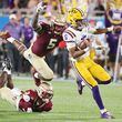 LSU quarterback Jayden Daniels (5) outruns leaping FSU defensive lineman Jared Verse (5) during the 2023 Camping World Kickoff college football game at Camping World Stadium in Orlando, Florida on Sunday, Sept. 3, 2023. (Stephen M. Dowell/Orlando Sentinel/TNS)