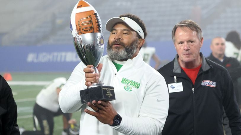 December 10, 2021 - Atlanta, Ga: Buford head coach Bryant Appling hoists the trophy after their 21-20 win against Langston Hughes during the Class 6A state title football game at Georgia State Center Parc Stadium Friday, December 10, 2021, Atlanta. JASON GETZ FOR THE ATLANTA JOURNAL-CONSTITUTION



