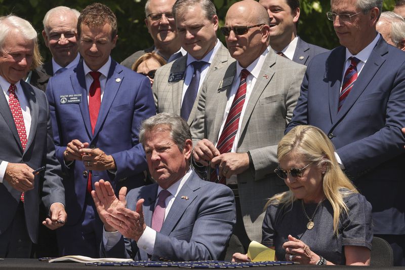 Georgia Gov. Brian Kemp claps after signing Senate Bill 233 known as the Georgia Promise Scholarship Act at Liberty Plaza on Tuesday, April 23, 2024. (Natrice Miller/Atlanta Journal-Constitution via AP)