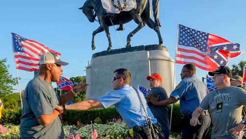 New Orleans Police separate two men after the two tussled, at the Gen. P.G.T. Beauregard monument in City Park in New Orleans, La. Tuesday, May 16, 2017. Workers in New Orleans took down a Confederate monument to Gen. P.G.T. Beauregard early Wednesday. (Matthew Hinton/The Advocate via AP)