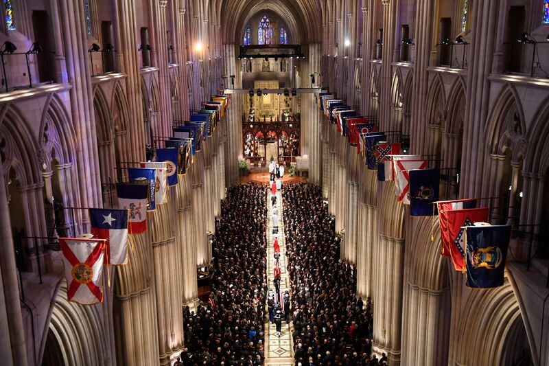 The flag-draped casket of former President George H.W. Bush is carried by a military honor guard during a State Funeral at the National Cathedral, Wednesday, Dec. 5, 2018, in Washington. George Fergus was the organist for the ceremony.