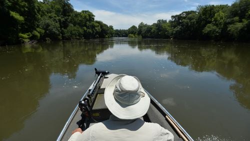 Glenn Cox, a fifth-generation farmer, guides his boat up the Flint River.