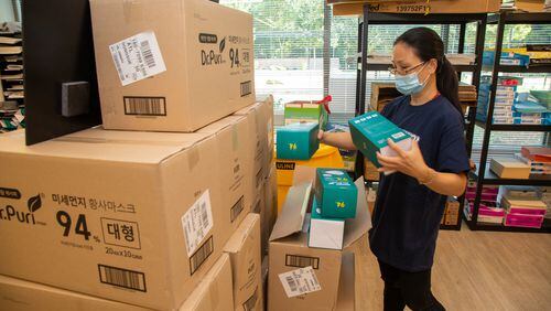 Global Ministries' Mei Lou pulls boxes of face masks out to send to people all over the USA at their Atlanta headquarters. PHIL SKINNER FOR THE ATLANTA JOURNAL-CONSTITUTION.