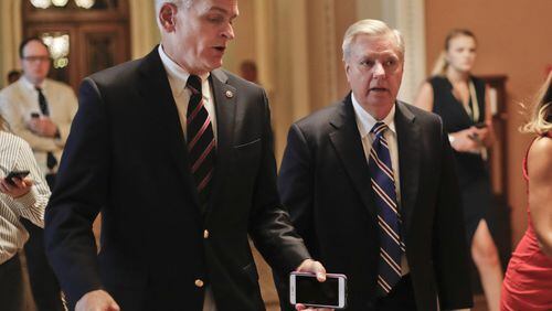 U.S. Sen. Bill Cassidy, R-La., left, and U.S. Sen. Lindsey Graham, R-S.C., talk while walking to a meeting on Capitol Hill in Washington in July. They are co-authors of the latest effort in the U.S. Senate to repeal and replace Obamacare. (AP Photo/Pablo Martinez Monsivais, File)