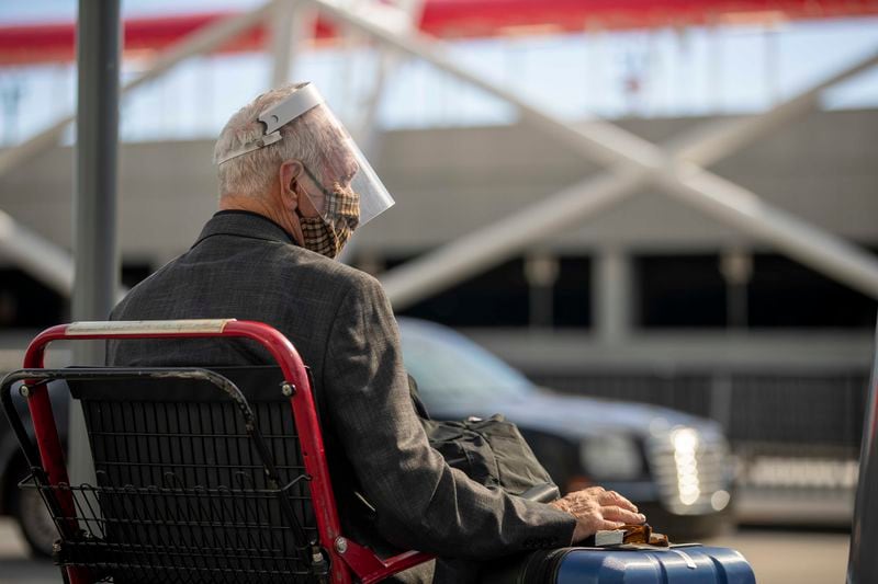 11/23/2020 �  Atlanta, Georgia �An elderly man wearing a face mask and a face shield holds onto hi luggage while waiting to be picked-up from the Domestic Terminal at Hartsfield-Jackson Atlanta International Airport in Atlanta , Monday, November 23, 2020.  (Alyssa Pointer / Alyssa.Pointer@ajc.com)