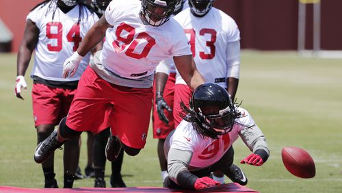 Derrick Shelby, left, knocks the ball away from Falcons teammate Courtney Upshaw during a drill at a practice Monday, May 23, 2016, in Flowery Branch. (AP Photo/David Goldman)