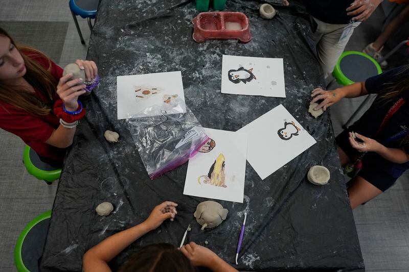 Ella Oliveri, 8, left, works alongside third grade classmates to sculpt clay models of endangered or vulnerable animal species, in Lindsey Wuest's Science As Art class, at A.D. Henderson School in Boca Raton, Fla., Tuesday, April 16, 2024. (AP Photo/Rebecca Blackwell)