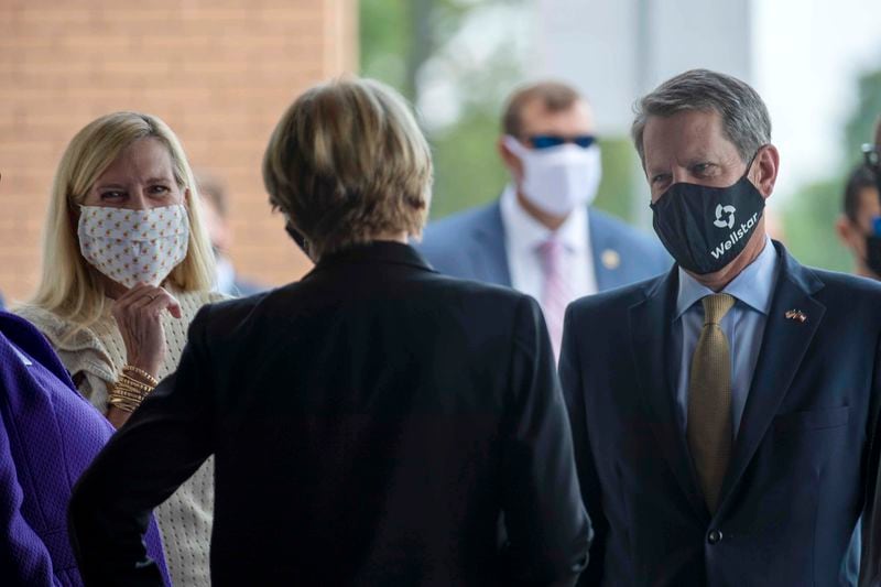 Wearing masks, Gov. Brian Kemp and first lady Marty Kemp are greeted as they arrive earlier this month at a ribbon-cutting ceremony for the new emergency department building at Wellstar Kennestone Hospital in Marietta. (ALYSSA POINTER / ALYSSA.POINTER@AJC.COM)