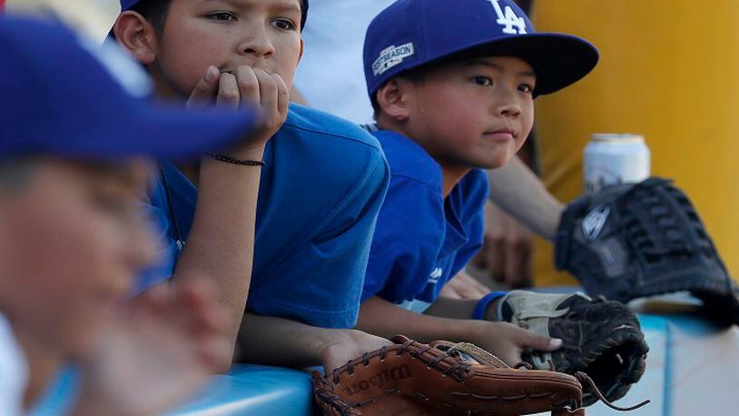 Young fans wait to snag souvenir balls during batting practice before the start of Game 1 of the World Series between the Los Angeles Dodgers and the Houston Astros at Dodger Stadium in Los Angeles on Tuesday, Oct. 24, 2017. (Luis Sinco/Los Angeles Times/TNS)