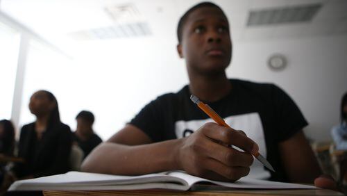 April 17, 2017, Atlanta, Georgia - Pierre Agudze, a student at Clark Atlanta University, takes notes during his calculus class at school in Atlanta, Georgia, on April 17, 2017. Clark Atlanta has the highest student debt in the state at around $40,000 and recently started a program called Finish in Four, which encourages students to take more credits in order to graduate on time and with less debt. (HENRY TAYLOR / HENRY.TAYLOR@AJC.COM)