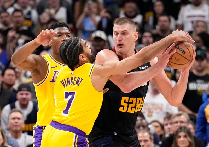 Los Angeles Lakers guard Gabe Vincent (7) pressures Denver Nuggets center Nikola Jokic, right, during the second half in Game 2 of an NBA basketball first-round playoff series Monday, April 22, 2024, in Denver. (AP Photo/Jack Dempsey)