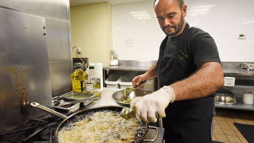 Samer, a Syrian refugee who asked that his last name not be published, makes falafel in a Mediterranean restaurant in downtown Atlanta. The war caused him to flee with his wife and newborn son to Jordan. HYOSUB SHIN / HSHIN@AJC.COM