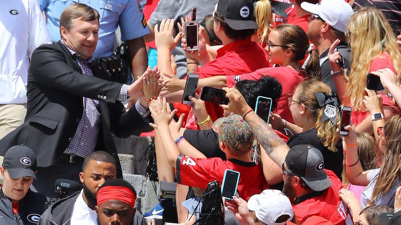 Georgia head coach Kirby Smart high-fives fans entering Sanford Stadium in the Dawg Walk before the Bulldogs’ annual “G-Day” spring game Saturday in Athens.