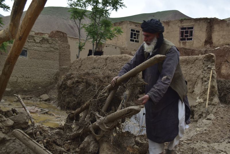 A man collects his belongings from his damaged home after heavy flooding in Baghlan province in northern Afghanistan Saturday, May 11, 2024. Flash floods from seasonal rains in Baghlan province in northern Afghanistan killed dozens of people on Friday, a Taliban official said. (AP Photo/Mehrab Ibrahimi)