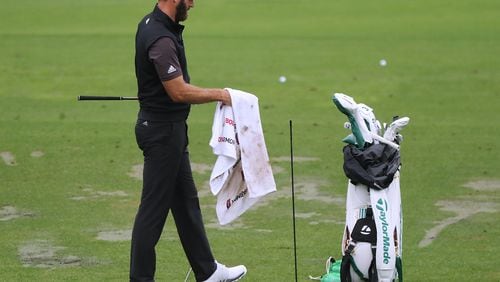 Dustin Johnson dries off his club while getting in some practice for the Masters on the range at Augusta National Golf Club on Wednesday, Nov 11, 2020, in Augusta.   “Curtis Compton / Curtis.Compton@ajc.com”