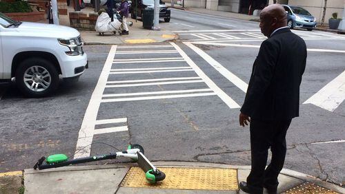 You’ll find scooters “parked” at the darndest places, like this one at a crosswalk next to Atlanta City Hall. Photo by Bill Torpy