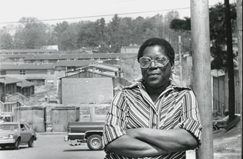 Eva Davis leans against a telephone pole, the buildings of of East Lake Meadows appear behind her. Atlanta, GA. September 8, 1986. (Credit: PBS)