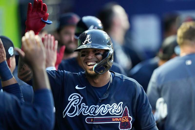 Atlanta Braves Orlando Arcia is greeted in the dugout after his two-run homer in the sixth inning of a spring training baseball game against the Philadelphia Phillies in North Port, Fla., Saturday, March 18, 2023. (AP Photo/Gerald Herbert)