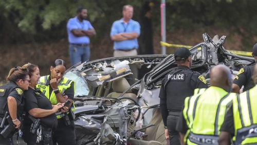 South Fulton police officers investigate a deadly crash on Fulton Industrial Boulevard last October. Georgia public safety officials say that if you're in a wreck, often the safest place to stay is in your car. (John Spink / John.Spink@ajc.com)