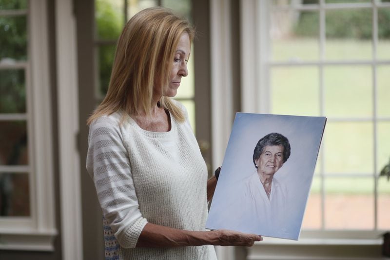 Gail Walker shows a photo of her mother, Lucile McMichael Brown, who died in 2015 after wandering out of an assisted living facility in Macon one night. Brown, a widowed great-grandmother and retired teacher, took a violent fall down a steep hill and broke her neck. Bob Andres/ robert.andres@ajc.com
