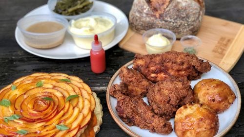 Takeout from Spring in Marietta: fried chicken dinner, with honey drop biscuits; braised greens; mashed potatoes; gravy and house-made hot sauce; peach tart and polenta sourdough. CONTRIBUTED BY WENDELL BROCK