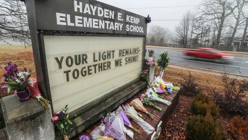 Flowers were laid side by side along the school sign in front of Kemp Elementary School in Powder Springs on Monday, Jan. 25, to remember Dana Johnson, a first-grade teacher. She died last Thursday morning, six weeks after she was admitted to the hospital, said principal Billy Pritz. Another Cobb school community is reeling from the loss of an educator. Cynthia Lindsey, a paraprofessional at Sedalia Park Elementary School, who also died Thursday after she was hospitalized earlier this month with COVID-19.  (John Spink / John.Spink@ajc.com)