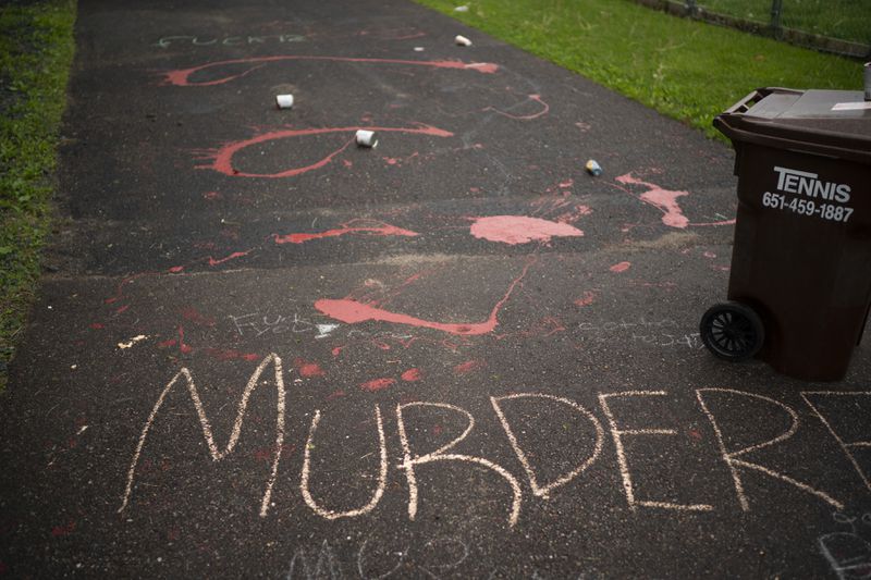 Splattered paint and chalk writing are on the driveway of the home of fired Minneapolis police Officer Derek Chauvin.