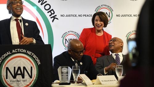 U.S. Sen. Amy Klobuchar of Minnesota laughs as the Rev. Al Sharpton tells the crowd at Paschal’s Restaurant that she once raised $17,000 from her ex-boyfriends. In all, five of the candidates who participated in Wednesday night’s Democratic presidential debate attended Thursday’s gathering put on by Sharpton’s National Action Network. Candidates made stops across the city on Thursday, many of them aiming to appeal to black voters. PHOTO BY ELISSA BENZIE