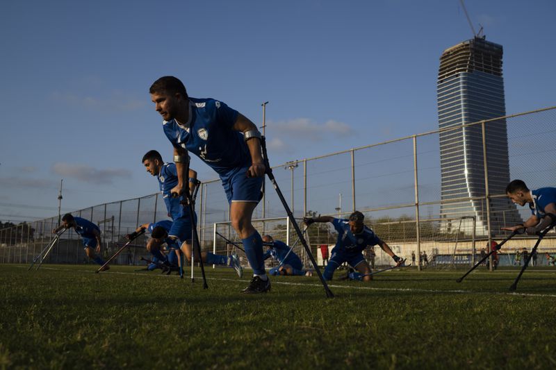 The soccer player of Israel Amputee Football Team, Ben Binyamin and his teammates prepare to run during a practice session in Ramat Gan, Thursday, April 11, 2024. Ben Binyamin was celebrating his 29th birthday at the Tribe of Nova music festival on Oct. 7 when Hamas militants stormed into southern Israel and opened fire on thousands of Israelis dancing to electronic music. Binyamin raced into an air raid shelter, but attackers fired shots and then threw in grenades. He was seriously wounded; his right leg was blown off. He was left for dead. (AP Photo/Leo Correa)