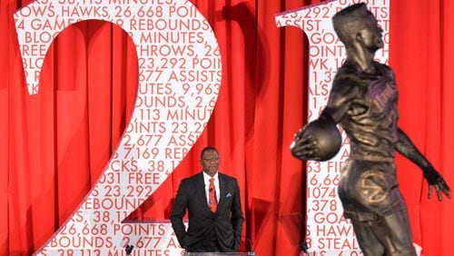 Dominique Wilkins gets emotional as he watches his statue is being unveiled at Philips Arena on Thursday, March 5, 2015. The Atlanta Hawks unveiled a large statue of former legendary Hawks player Dominique Wilkins on Thursday at Philips Arena. Measuring 13½ feet in height, the granite statue was unveiled at a private luncheon and ceremony on the arena floor. Made with a Nikon D4 camera, 200-400MM lens at focal length 220MM, 1/160 second, F4, and an ISO of 4000. HYOSUB SHIN / HSHIN@AJC.COM