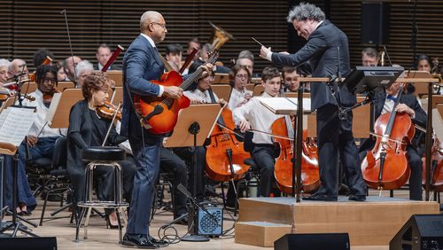 This image released by the New York Philharmonic shows former New York Yankees baseball player Bernie Williams, standing left, with conductor Gustavo Dudamel as he makes his New York Philharmonic debut in New York on Wednesday, April 24, 2024. (Brandon Patoc/New York Philharmonic via AP)